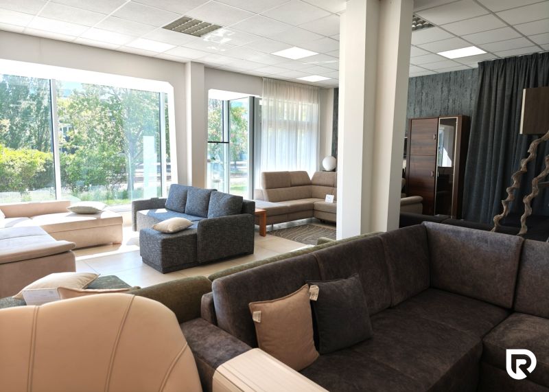 Sofas and armchairs in commercial spaces with large windows and wood-patterned flooring.