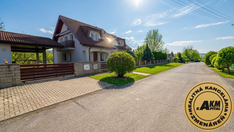 A family house in Sliač, a spacious street surrounded by green trees and a blue sky.