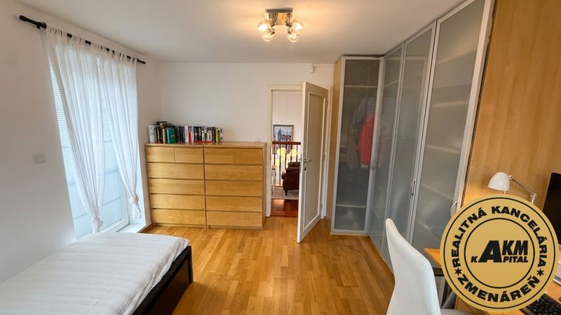 A bedroom in a family house with a wooden decor floor and a wardrobe.