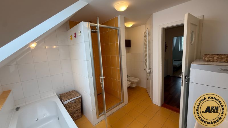 A bathroom in a family house with a bathtub, shower, and orange tiles.