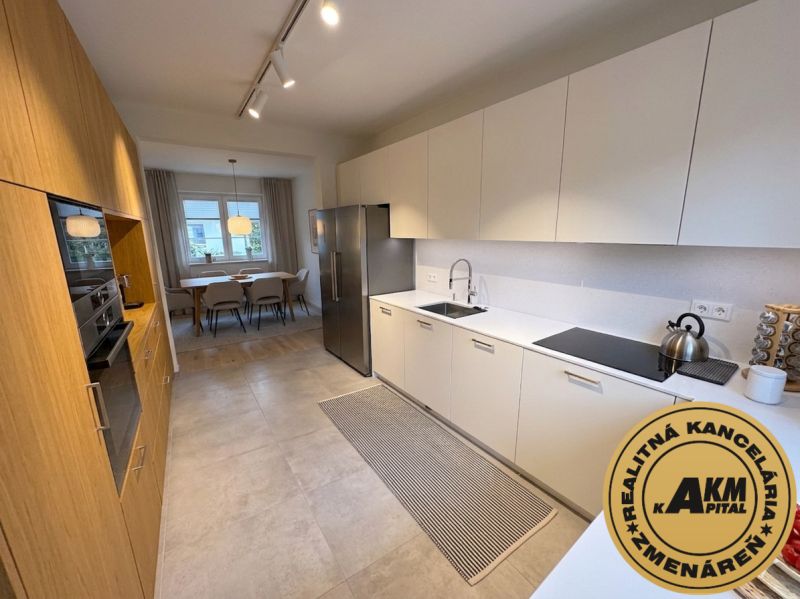 Bright kitchen and dining room in a family house with wood-patterned flooring.