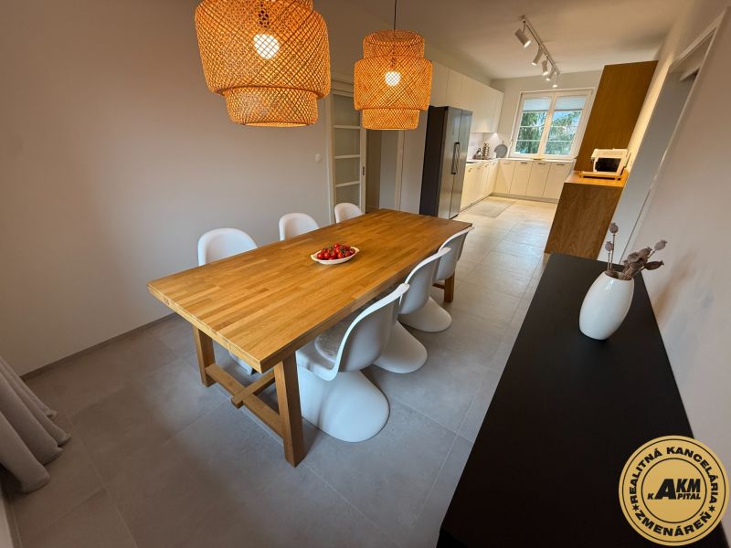 Dining area with wood-patterned flooring and rattan lamps in a family house.