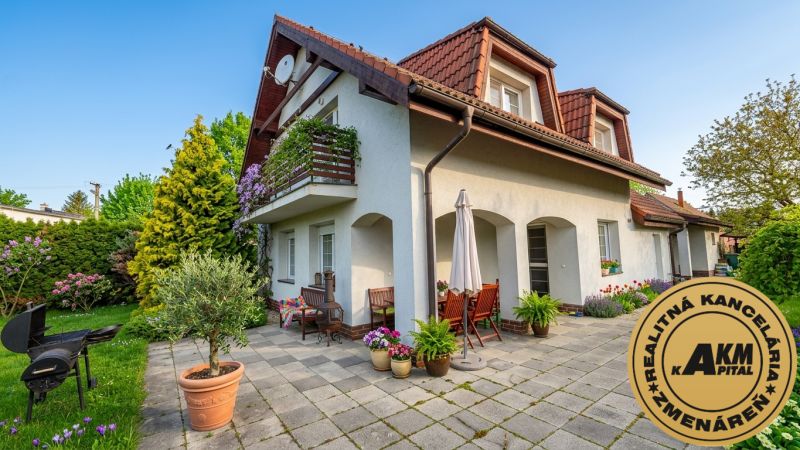 A family house in Sliač with a terrace, garden furniture, and a colorful garden.