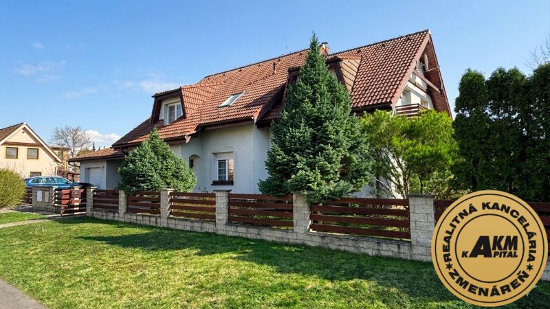 A family house in Sliač with a wooden fence and a landscaped garden.