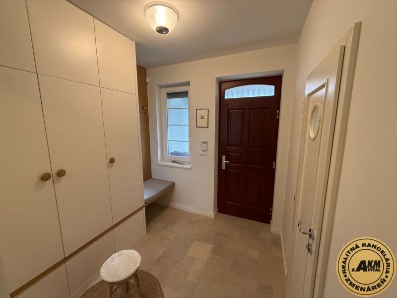 Entrance hall in a family house with white storage space and brown doors.