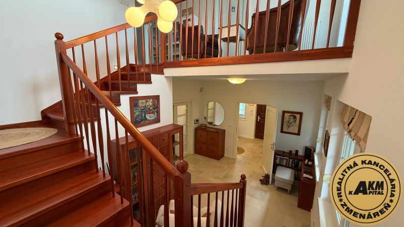 A staircase with a wooden railing and an entrance hall in a family house.