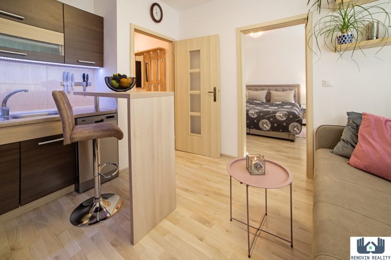 1-bedroom apartment with a kitchen, living room, wooden floor decor, comfortable seating.