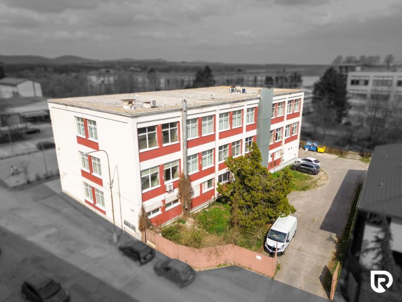The building on Jána Zigmundíka Street in Vrbové surrounded by greenery and cars.