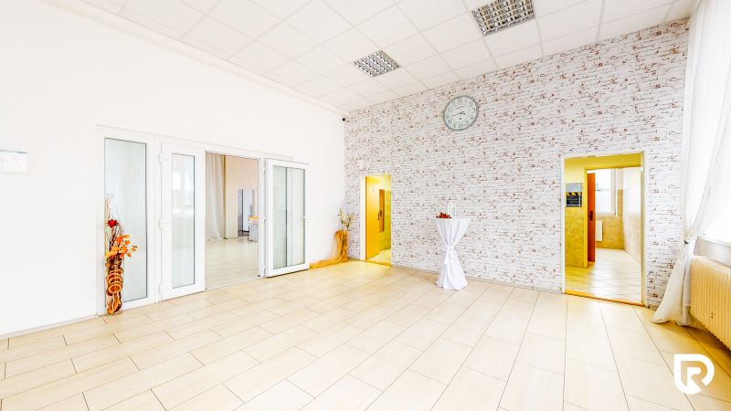 Interior of commercial spaces with wood-patterned flooring and brick-patterned wall.