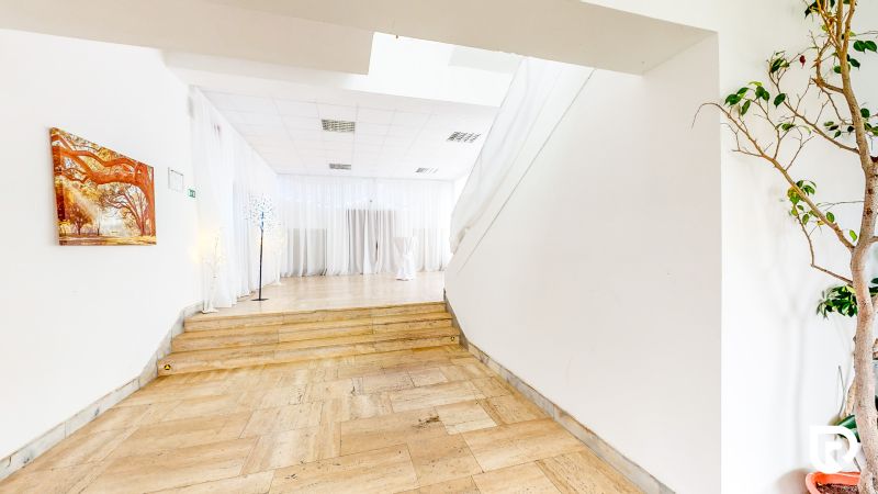Interior of commercial spaces with white curtains and wood-patterned flooring.
