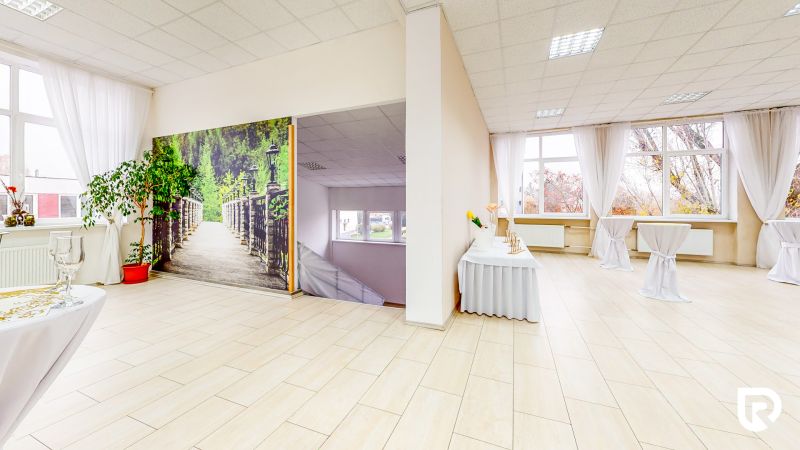 Commercial space with wood-patterned flooring, white curtains, and a photograph of a garden.
