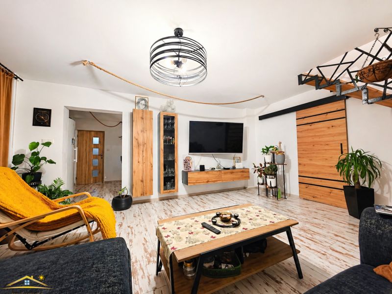 Living room with wood-patterned flooring and wooden furniture in a family house.