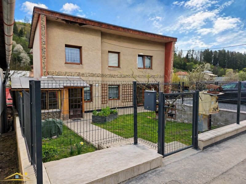 A family house in Zákopčie with a garden, lawn, and metal fence.