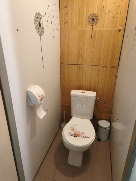 Bathroom in a 2-room apartment with decorative elements and a wooden decor floor.