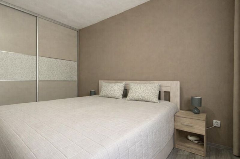 A bedroom with a large bed and a wardrobe in a 4-room apartment.