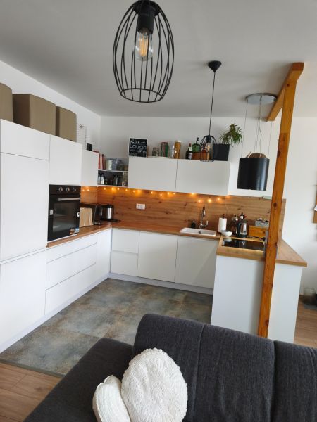 A kitchen in a 4-room apartment with white cabinets and wood decor.