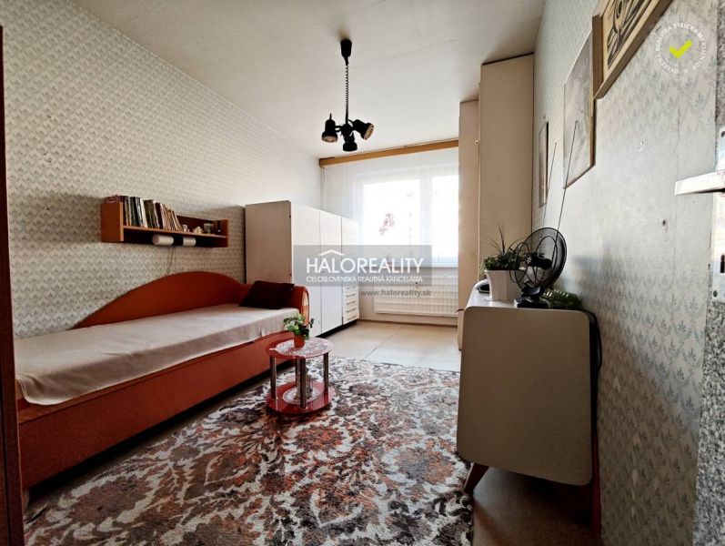 Interior of a 2-room apartment with carpeted floor, bed, and cabinet.
