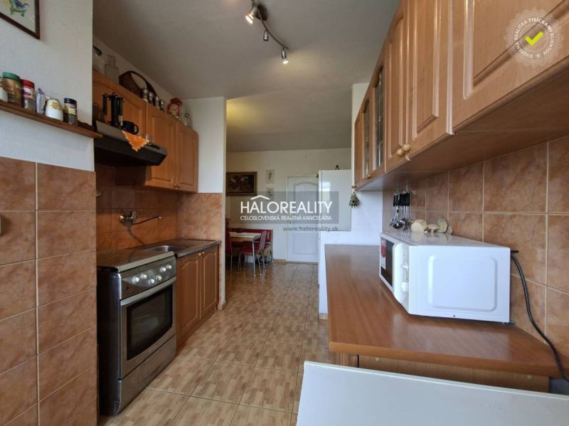 A kitchen in a 3-room apartment with wooden decor and appliances.