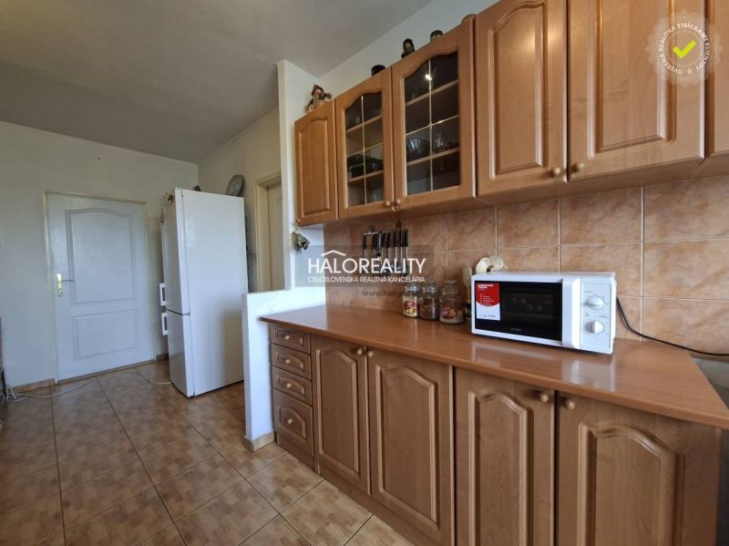 A kitchen in a 3-room apartment with built-in cabinets and a wooden decor floor.