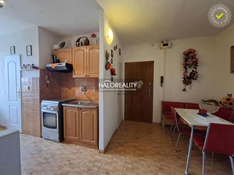 Kitchen in a 3-room apartment, floor with wooden decor, dining table, cabinets.