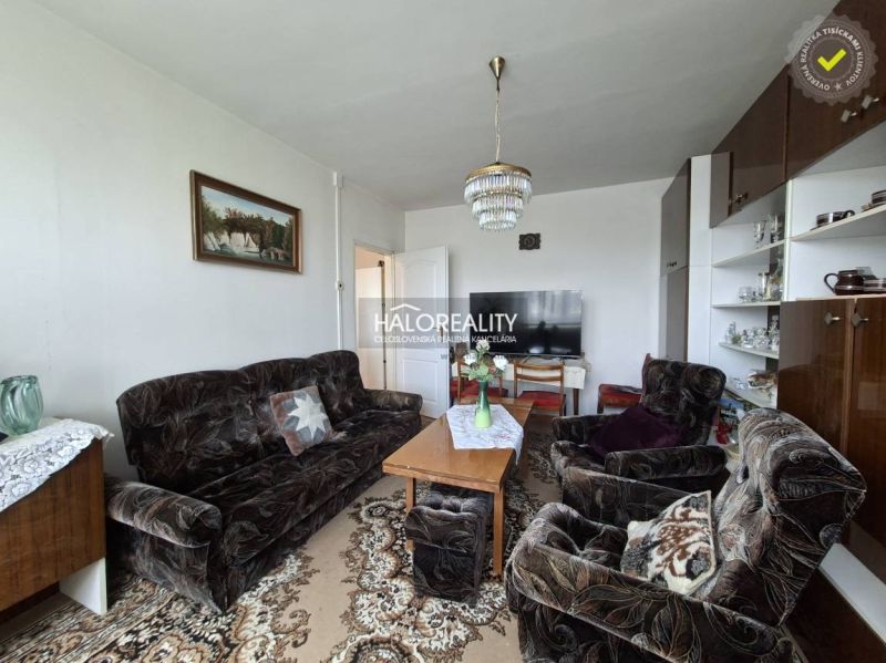 Living room in a 3-room apartment with a dark sofa set and carpet decor.