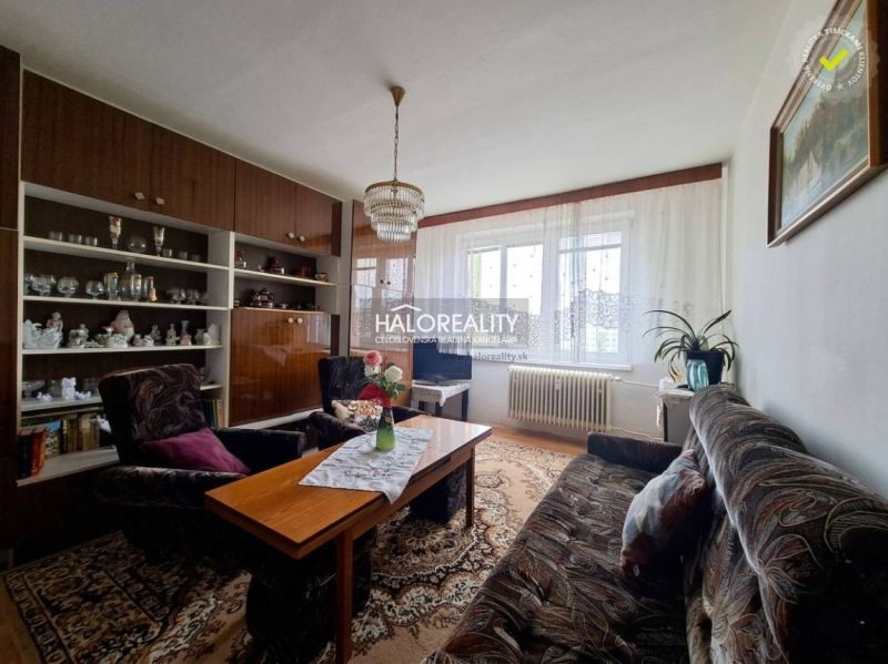 Living room in a 3-room apartment with comfortable furniture and a wall display cabinet.