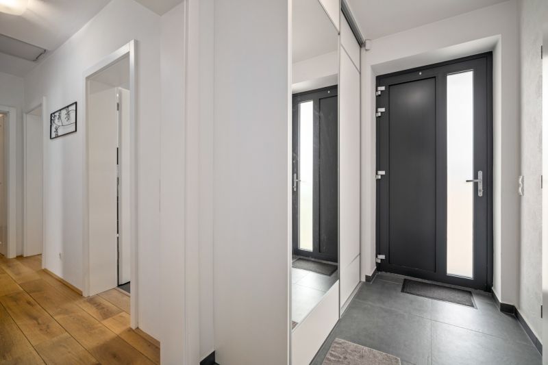 Interior of a family house with a wooden decor floor and glass doors.