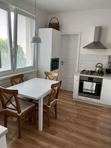 A kitchen in a 3-room apartment with a dining table and a wooden decor floor.