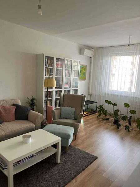 Living room in a 3-room apartment with comfortable furniture and a wooden decor floor.