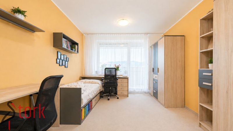 A room with light walls, wooden decor furniture, and a bed in a 3-room apartment.