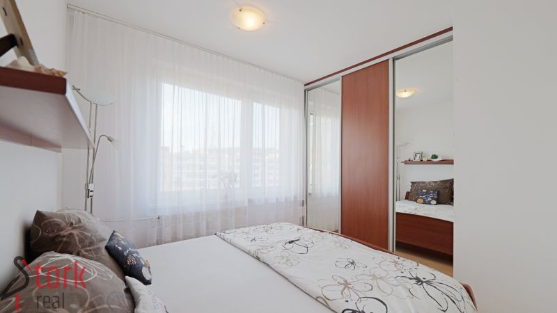 Bedroom in a 3-room apartment with a large mirrored wardrobe and delicate curtains.