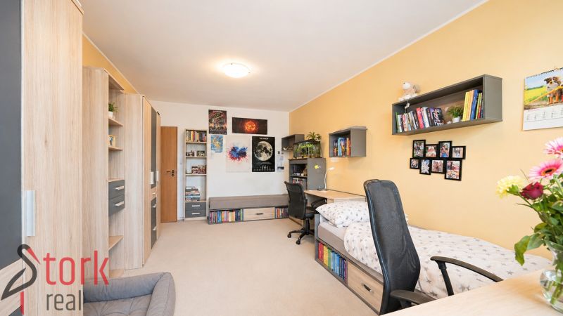 A children's room in a 3-room apartment with wooden decor, featuring a desk and a bed.