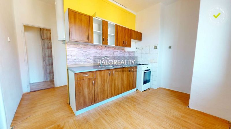 A kitchen with wooden decor in a 2-room apartment, light walls, built-in stove.
