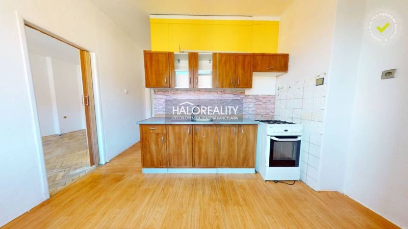 A kitchen in a 2-room apartment with a wooden decor countertop and floor.