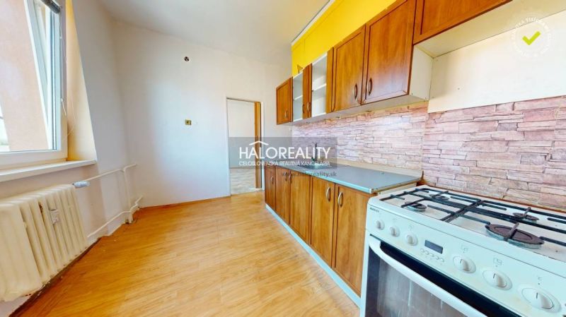 A kitchen in a 2-room apartment with a wooden decor floor and a gas stove.