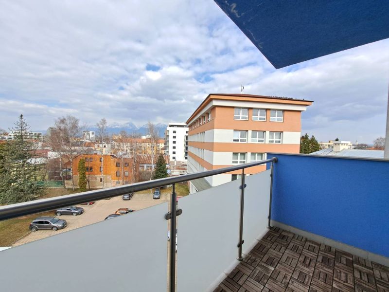 View from the balcony of a 3-room apartment in Poprad, parking, and surrounding architecture.