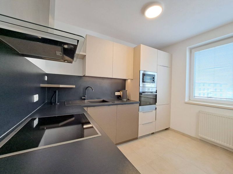 A kitchen in a 3-room apartment with a cooktop and light furnishings.