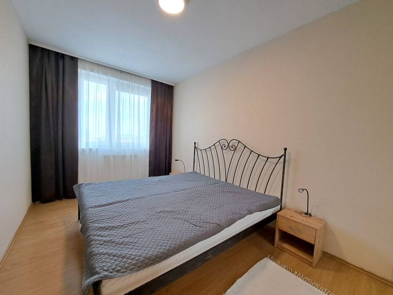 A bedroom with a metal bed and a wooden decor floor in a 3-room apartment.