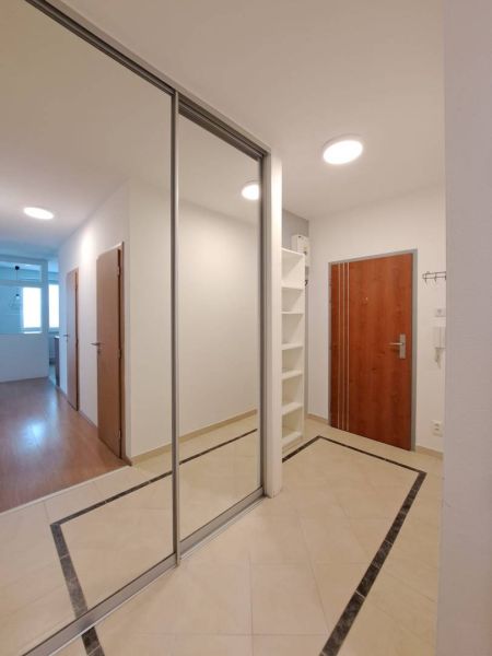 Entrance hall in a 3-room apartment with a large mirrored wardrobe and tiles.