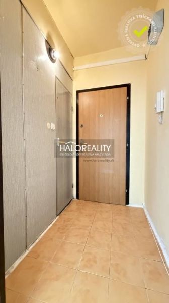 Studio apartment with tiled entrance hall, neutral walls, wooden door decor.