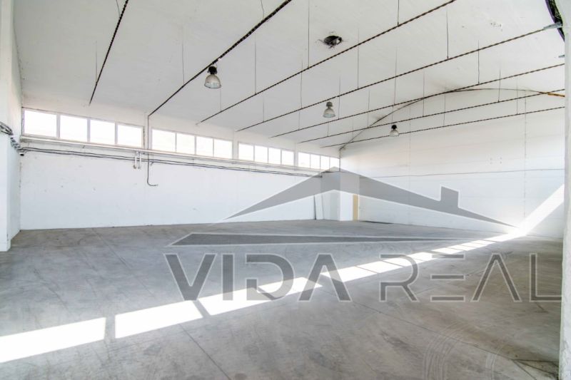 Spacious interior of warehouses and halls with concrete flooring and lighting.