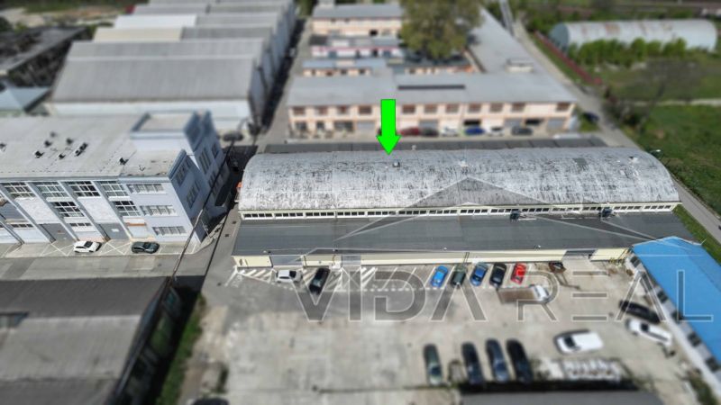 A view of warehouses and halls on Coburgova Street in Trnava with a parking lot full of cars.