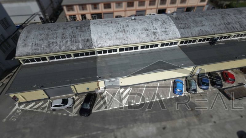 A top-down view of warehouses and halls on Coburgova Street in Trnava. A parking lot with cars.