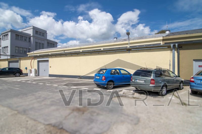 Parking lot near warehouses and halls on Coburgova Street in Trnava with several cars.