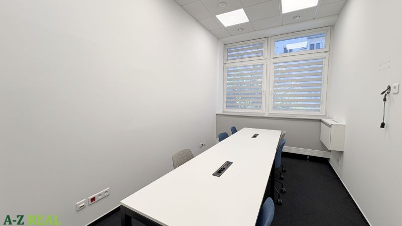 Offices with a white desk and office chairs, with a large window in the room.