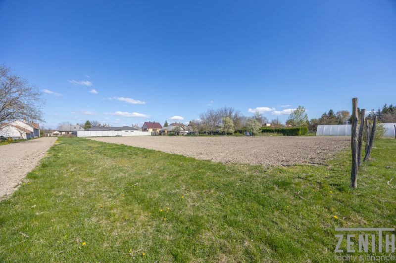 Plots - residential with grassy area in Dunakiliti, with visible houses in the background.