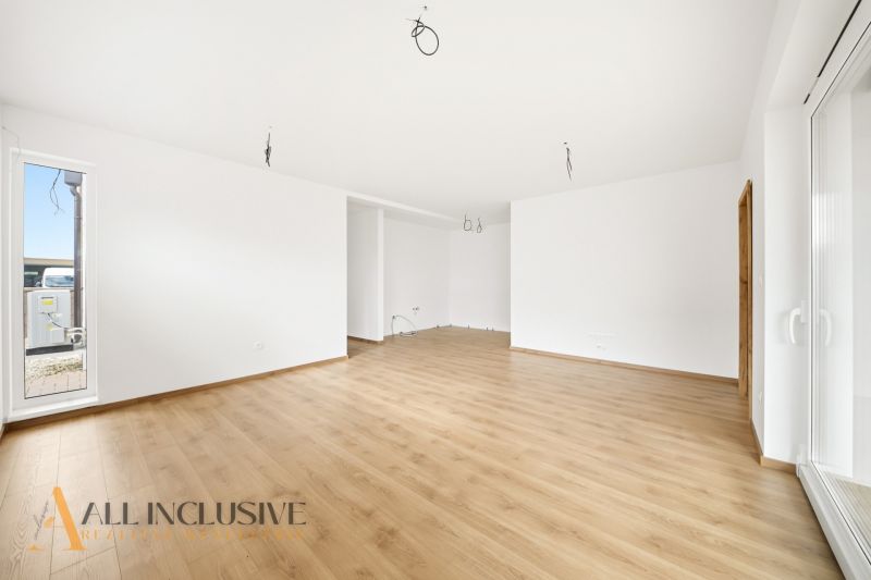 A spacious room in a family house with a wooden decor floor and large windows.