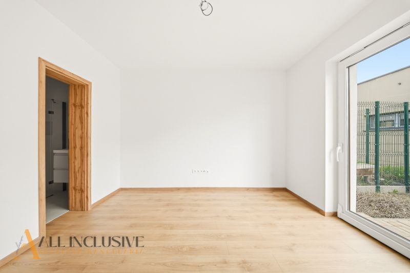 A room in a family house with a wooden decor floor and a spacious window.