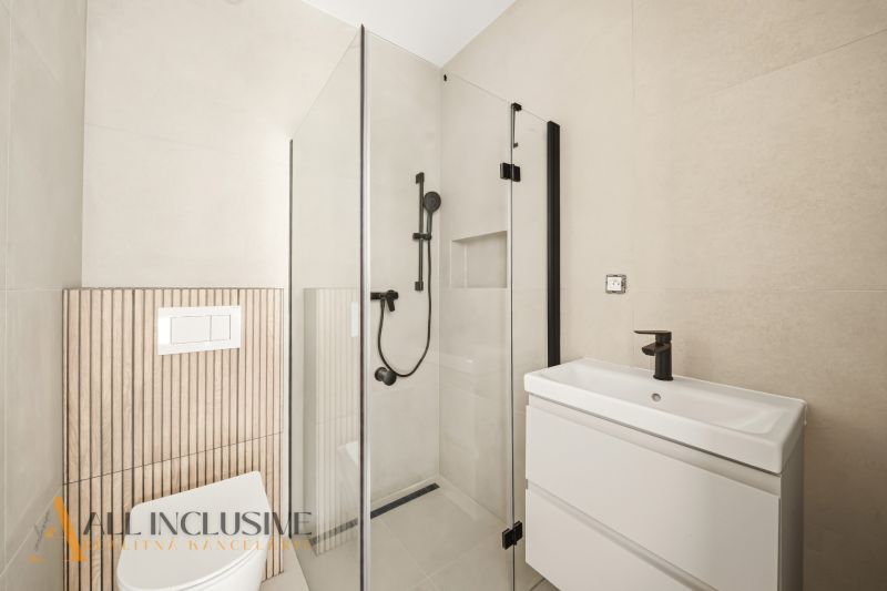 The bathroom of a family house with a modern shower and stylish white sanitary ceramics.