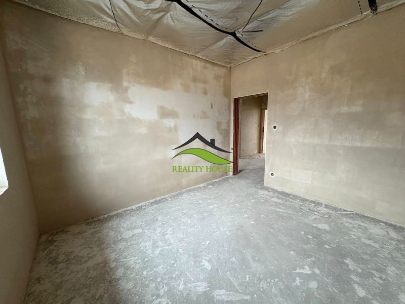An unplastered room in a family house with a wooden decor floor.